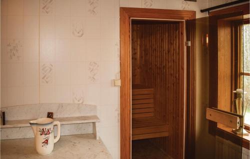 a bathroom with a door and a vase on the floor at Awesome Home In Skillingaryd With 3 Bedrooms And Sauna in Södra Nässja