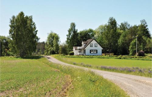 a house in the middle of a field with a dirt road at Beautiful Home In Säffle With Kitchen in Säffle