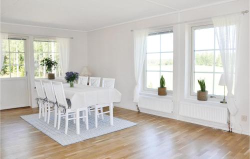 a white dining room with a white table and chairs at Beautiful Home In Säffle With Kitchen in Säffle