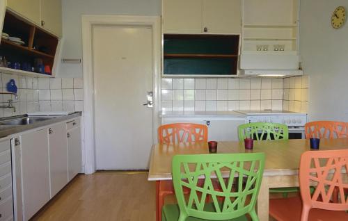 une cuisine avec une table et des chaises et une cuisine avec des placards blancs dans l'établissement Awesome Home In Tomelilla With 5 Bedrooms, à Bollerup
