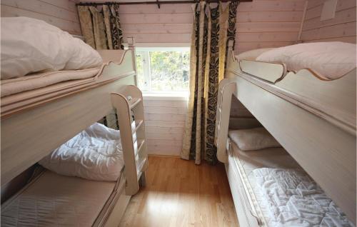 SjusjøenにあるBeautiful Home In Sjusjen With 3 Bedrooms, Sauna And Wifiの二段ベッド2台と窓が備わる客室です。