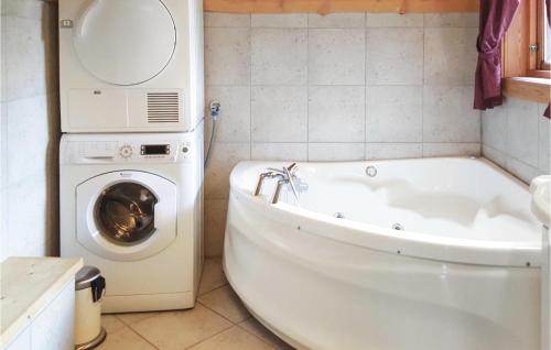 y baño con lavadora y bañera blanca. en Hytte Nr, 4-156, en Frafjord