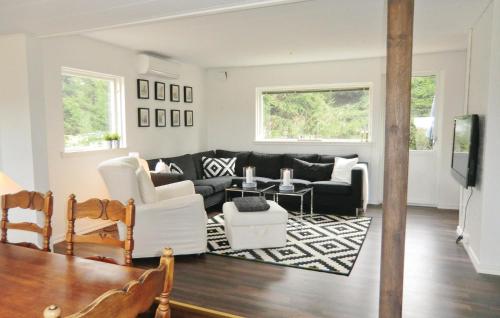 a living room with a black couch and white furniture at Nice Home In Örkelljunga With Kitchen in Fasalt