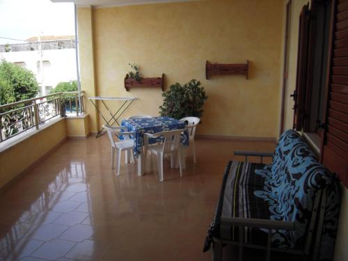 a room with a table and chairs on a balcony at Dream Beach Salento in Porto Cesareo