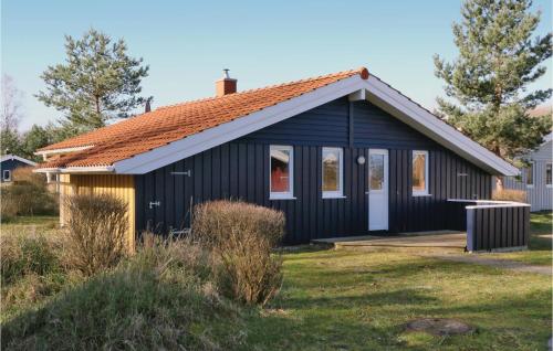 a black house with a red roof at Frische Brise 20 - Dorf 3 in Priwall