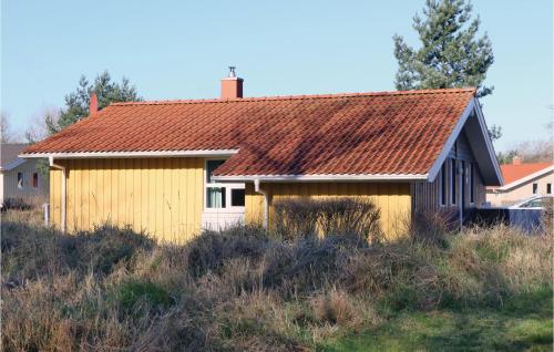 a yellow house with a rusty roof on a field at Frische Brise 20 - Dorf 3 in Priwall