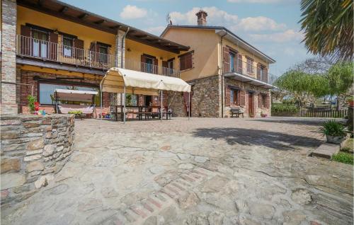 un gran edificio con patio y sombrilla en Nice Home In Marsaglia Cn With Jacuzzi, en Belvedere Langhe
