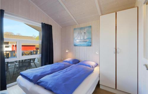 um quarto com uma cama com lençóis azuis e uma janela em Frische Brise 23 - Dorf 3 em Priwall