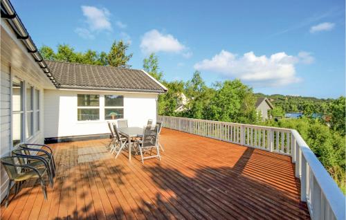 a deck with chairs and a table on a house at 4 Bedroom Cozy Home In Auklandshamn in Vestvik