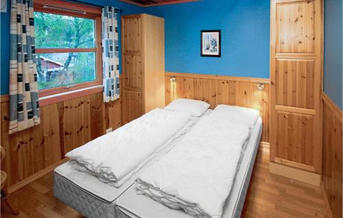 Cama en habitación con paredes azules y ventana en 4 Bedroom Cozy Home In Auklandshamn, en Vestvik