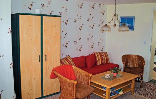 LassanにあるBeautiful Apartment In Lassan With Kitchenのリビングルーム(赤いソファ、テーブル付)