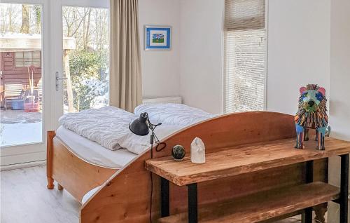 1 dormitorio con cama y mesa de madera en Nice Home In Exloo With Kitchen, en Exloo