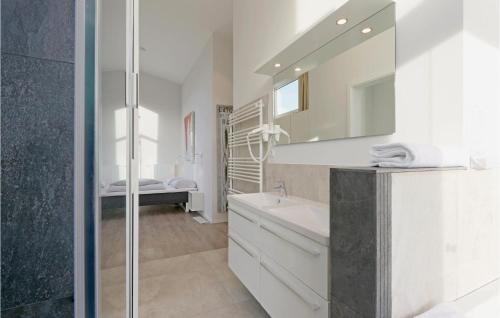 a white bathroom with a sink and a mirror at Dünenvilla 6, Whg 5 in Travemünde