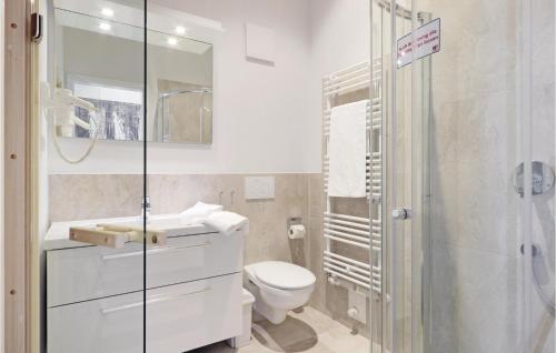 a bathroom with a toilet and a glass shower at Dünenvilla 6, Whg 5 in Travemünde