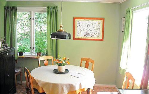 2 Bedroom Awesome Home In Mrbylnga في Stora Frö: غرفة طعام مع طاولة وطاولة وكراسي