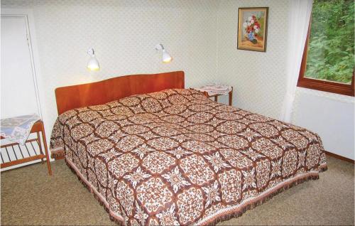2 Bedroom Awesome Home In Mrbylnga في Stora Frö: غرفة نوم مع سرير مع لحاف عليه