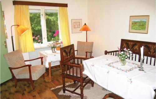 een eetkamer met een tafel en stoelen en een raam bij 2 Bedroom Awesome Home In Mrbylnga in Stora Frö
