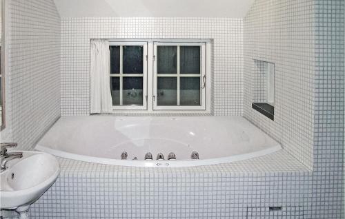 a white bathroom with a tub and a sink at Cozy Home In Gl With Sauna in Gålå