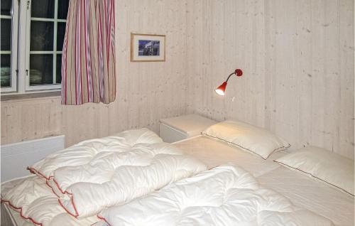 a bed with white sheets and a lamp in a room at Cozy Home In Gl With Sauna in Gålå