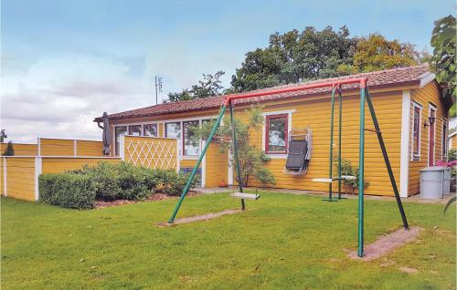 a swing set in front of a house at Gorgeous Home In Harlösa With Wifi in Harlösa