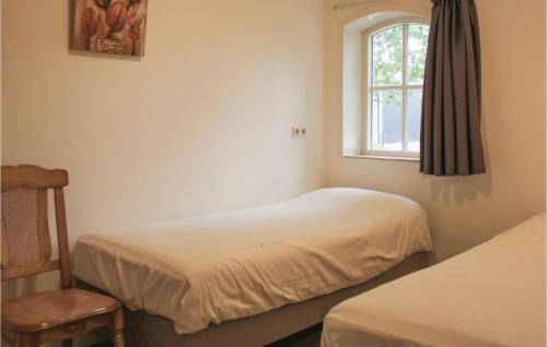 a bedroom with two beds and a window at Dorsvloer in De Moer