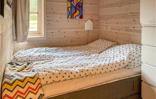 a bed in a bedroom with a wooden wall at Cozy Home In Vikes With House A Mountain View in Vikeså