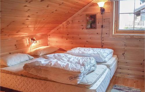 a bedroom with two beds in a log cabin at Lovely Home In seral With House A Mountain View in Ljosland