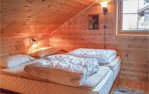LjoslandにあるAmazing Home In seral With 4 Bedrooms And Saunaのログキャビン内のベッドルーム1室(ベッド2台付)