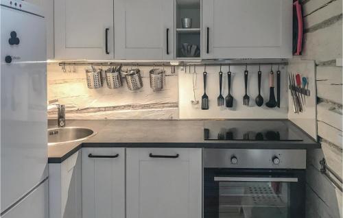 una cocina con armarios blancos y fregadero en Gorgeous Home In Tystberga With Kitchen en Tystberga