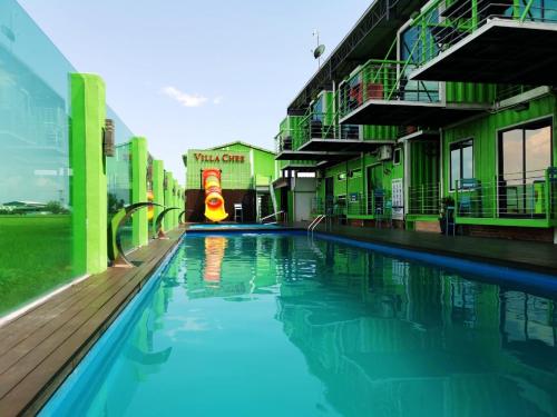 a swimming pool next to a building with aqual at Villa Chee in Sekincan