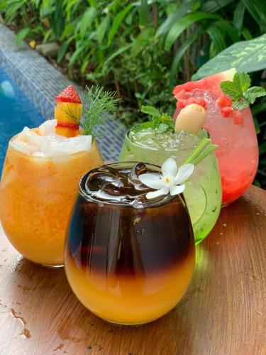 a wooden table with two cocktails and a drink at Grand Kangen Hotel Urip Sumoharjo in Yogyakarta