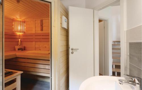 ein Badezimmer mit einer Sauna neben einem Waschbecken in der Unterkunft Ferienhausdorf Thale in Thale