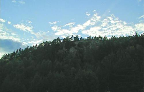 a hillside with trees and a blue sky with clouds at Holiday Home Dalarna Strömstad Ii in Lommeland