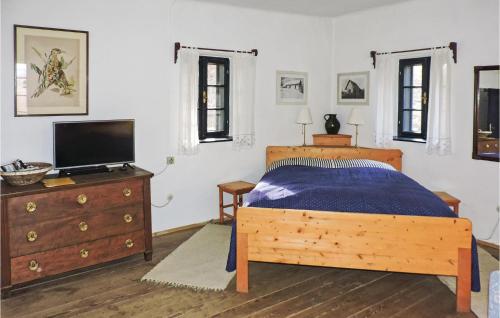 - une chambre avec un lit et une commode avec une télévision dans l'établissement Ferienhaus Gerersdorf-gssing, à Gerersdorf bei Güssing