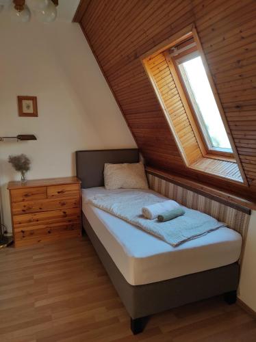 a small bedroom with a bed and a window at Füvesi Vendégház in Balatonfüred