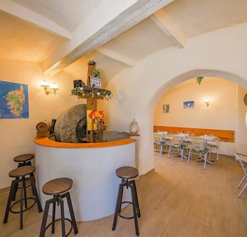 un restaurante con bar con taburetes en una habitación en Casa di Emma, en Santo-Pietro-di-Tenda