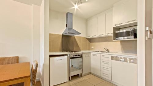 a kitchen with white cabinets and a stove top oven at Chalet Hotham 20 in Mount Hotham