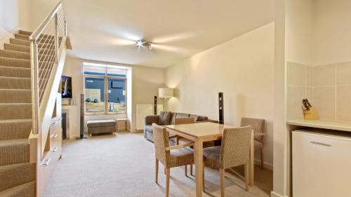 a dining room and living room with a table and chairs at Chalet Hotham 20 in Mount Hotham