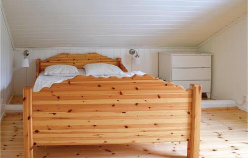 un letto in legno con due cuscini in una camera da letto di 3 Bedroom Cozy Home In Aurskog a Urskog
