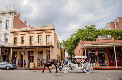 a horse pulling a carriage on a city street at Kimpton Sawyer Hotel by IHG in Sacramento