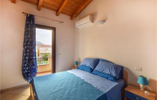 um quarto com uma cama azul e uma janela em Cozy Home In Viddalba With Kitchen em Viddalba