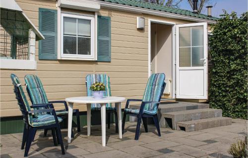a table and chairs on a patio in front of a house at 2 Bedroom Nice Home In Tzummarum in Tzummarum