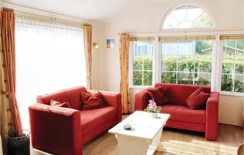 a living room with two red couches and a table at 2 Bedroom Nice Home In Tzummarum in Tzummarum