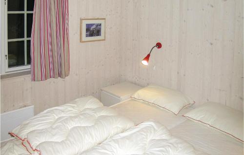 a bed with white sheets and a lamp in a room at Awesome Home In Gl With House A Mountain View in Gålå