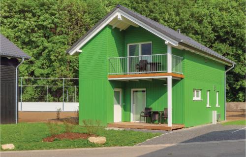 a green house with a balcony on top of it at Ferienhausdorf Thale in Thale