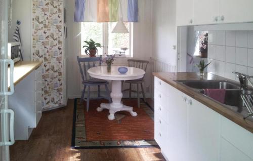a kitchen with a white table and a sink at Stunning Home In Kosta With 2 Bedrooms And Wifi in Kosta