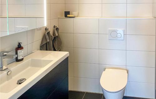 uma casa de banho com um WC branco e um lavatório. em Amazing Apartment In Svanesund With Kitchen em Svanesund