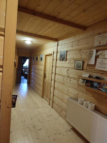 a room with a wooden wall with a hallway at Dom Cypryda in Chochołów