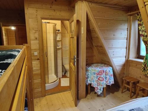 a wooden cabin with a staircase leading to a bathroom at Dom Cypryda in Chochołów