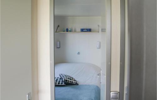 een kleine slaapkamer met een bed met een spiegel bij Huisje Blauwe Hoek in Westerland